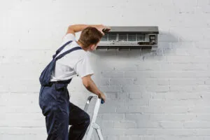 rsz rear view of air conditioner repairman standing on 2023 11 27 05 21 54 utc 300x200 1